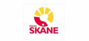 Rexuma vårdrumspanel Logotyp för Region Skåne med en stiliserad röd och gul grafik som liknar en sol och en fågel, med texten REGION SKANE i feta röda bokstäver under - vanligt förekommande vid sjukhusentréer eller i närheten av Vårdrumspanelens skyltar.
